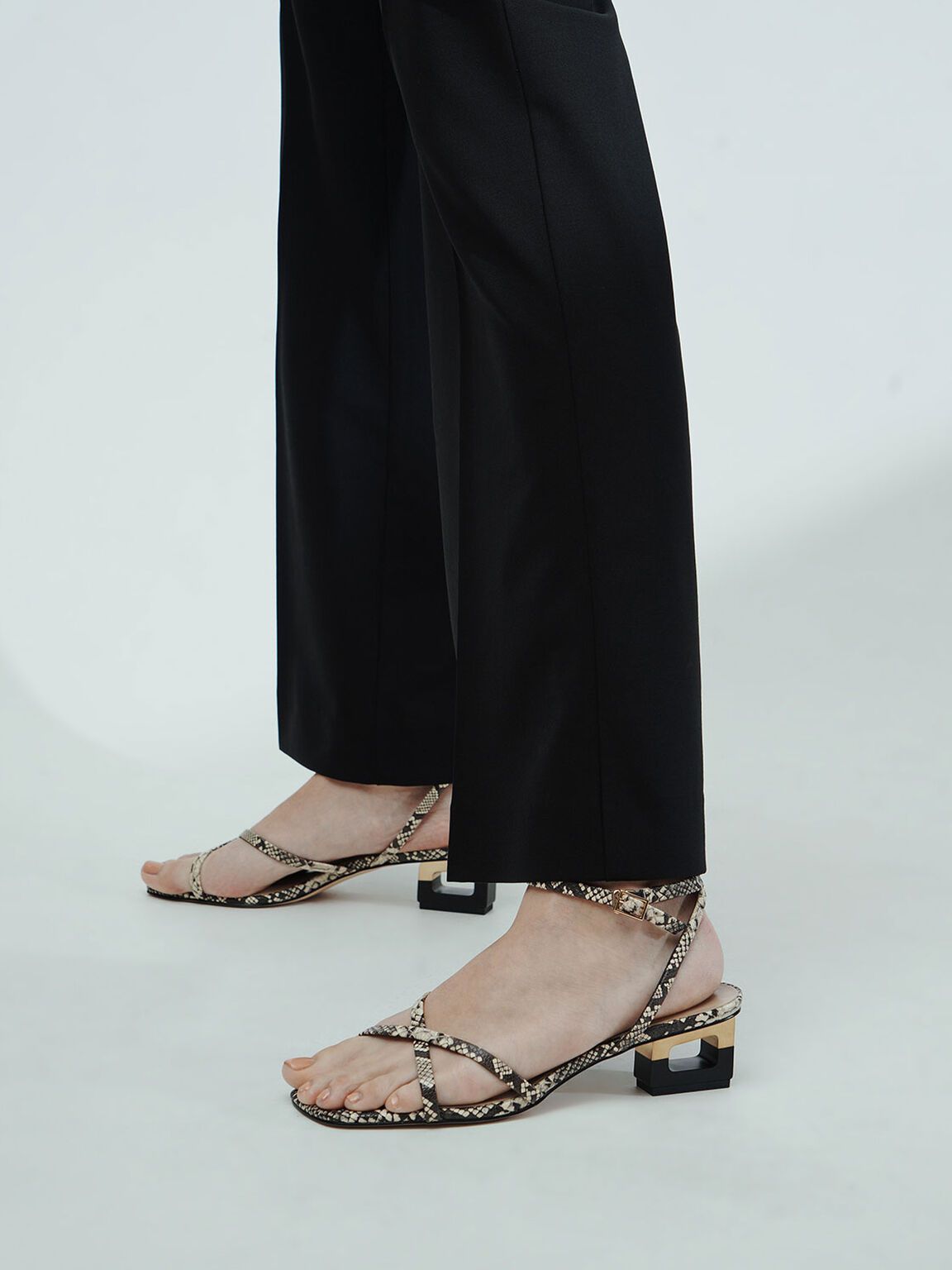 Skulpturale Sandalen mit Chromabsatz und Schlangenmuster